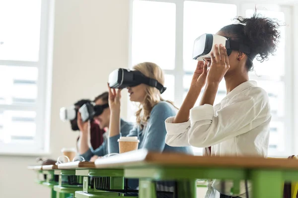 Selective focus of multiethnic students using vr headsets in university — Stock Photo