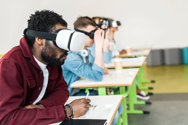 Selective focus of multiethnic students using vr headsets in university — Stock Photo