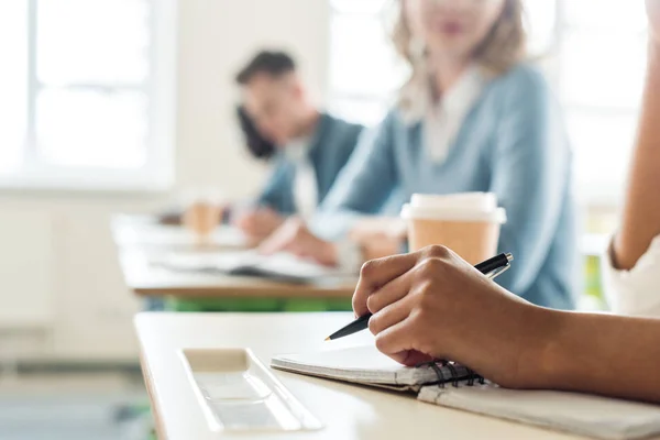 Vista cortada do estudante com caneta e notebook na universidade — Fotografia de Stock