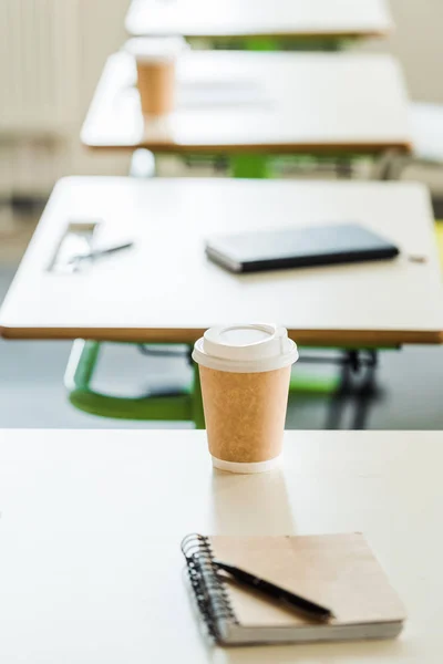Вибірковий фокус ноутбука та одноразової чашки на столі в університеті — стокове фото