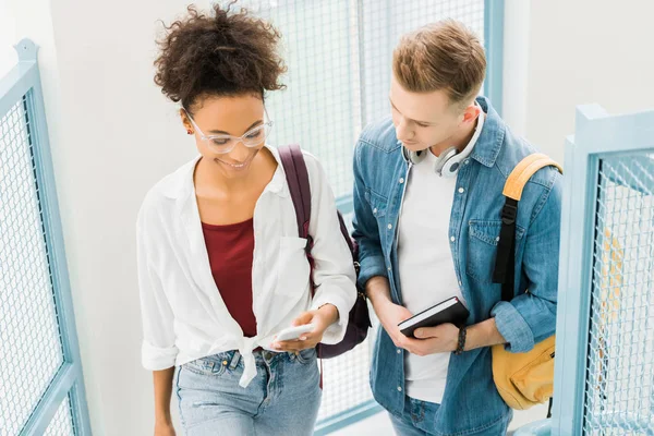 Dois estudantes multiculturais com notebook e smartphone na faculdade — Fotografia de Stock