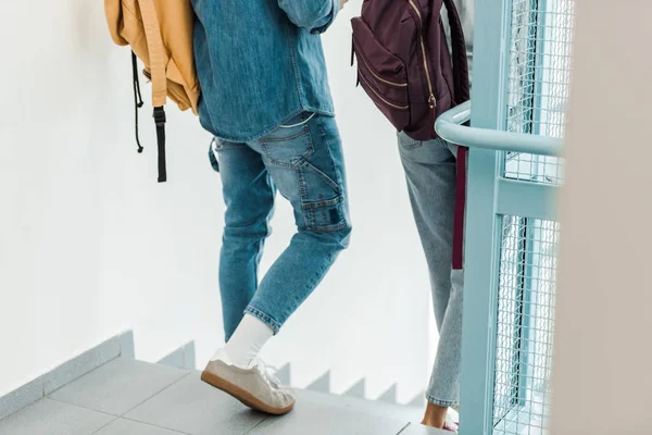 Cropped view of two students with backpacks in college — Stock Photo