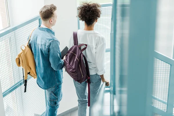 Visão traseira de dois estudantes internacionais com mochilas — Fotografia de Stock