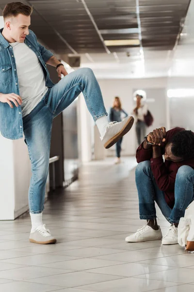 Два студента в джинсах дерутся в коридоре в колледже — стоковое фото