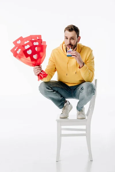 Uomo sorridente con mazzo di carte tagliate di carta rossa con cuori simboli che tengono pacchetto di sigarette con logo instagram su sfondo bianco — Foto stock