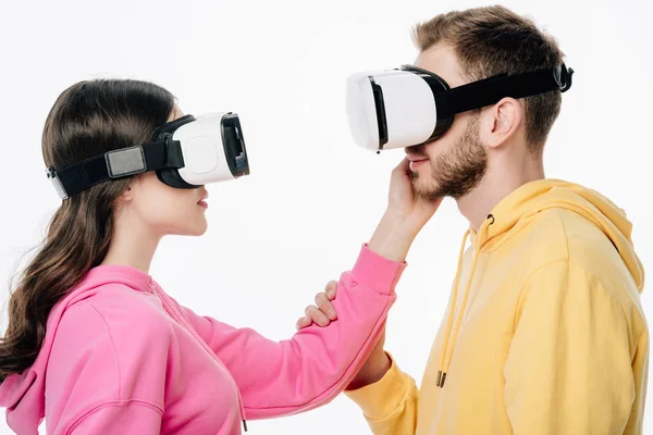 Young girl in virtual reality headset touching boyfriends face isolated on white — Stock Photo