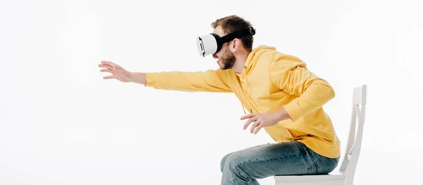 Panoramic shot of man outstretching hand while using virtual reality headset isolated on white — Stock Photo