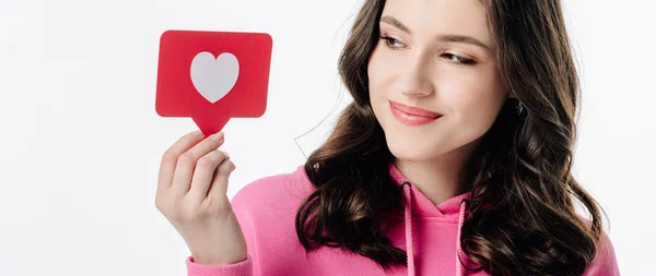 Plan panoramique de jolie fille tenant carte de papier rouge avec symbole de coeur isolé sur blanc — Photo de stock