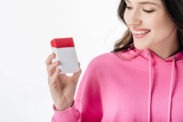 Attractive smiling girl in pink hoodie holding cigarette pack isolated on white — Stock Photo