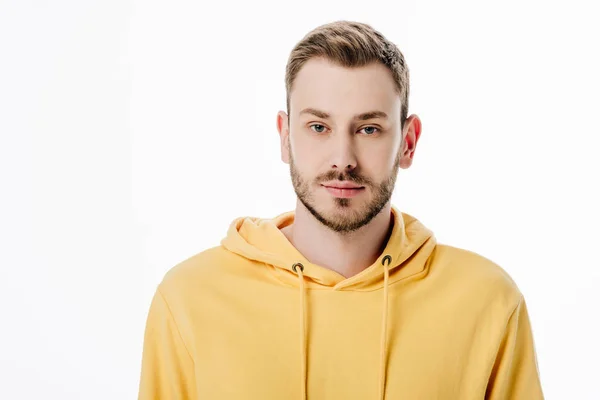 Bel homme réfléchi en sweat à capuche jaune regardant la caméra isolé sur blanc — Photo de stock