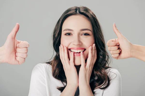 Cropped view of man and woman showing thumbs up near excited girl isolated on grey — Stock Photo