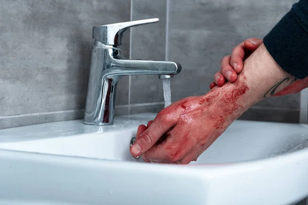 Vue partielle de l'homme se lavant les mains saignantes dans l'évier — Photo de stock