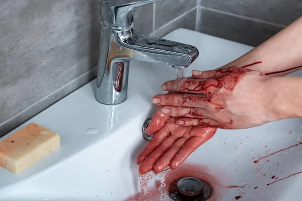 Vista parcial de la mujer lavándose las manos sangrantes en el baño - foto de stock