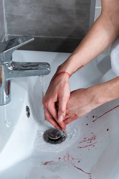 Partial view of woman washing bleeding hands in bathroom — Stock Photo