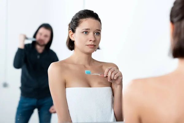 Killer attacking woman with knife while she brushing teeth in bathroom — Stock Photo