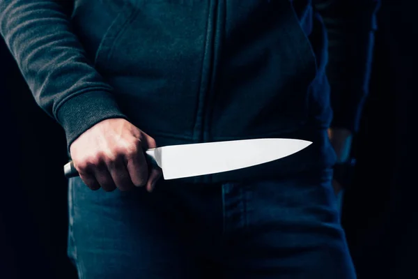 Cropped view of murderer holding knife isolated on black — Stock Photo