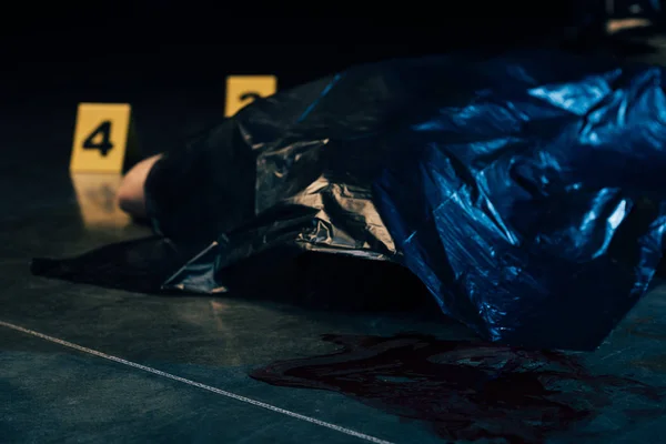 Cadáver coberto com marcadores de provas na cena do crime — Fotografia de Stock