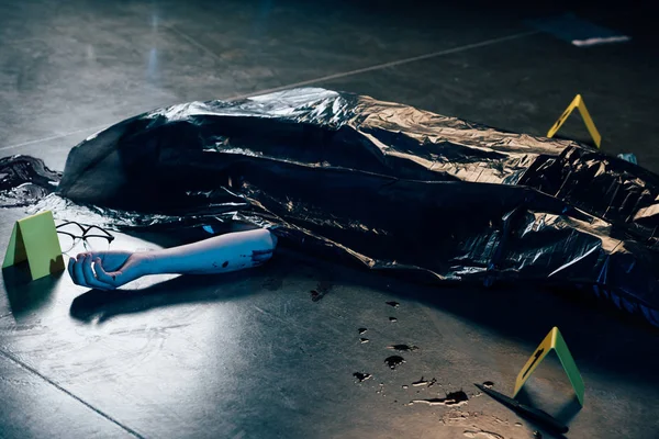 Covered corpse with glasses on floor at crime scene — Stock Photo