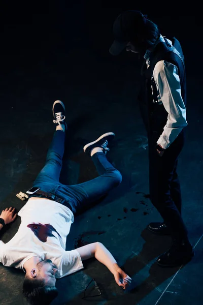 Overhead view of investigator in uniform standing near corpse at crime scene — Stock Photo