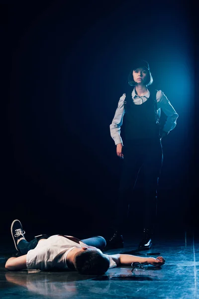 Investigator in uniform standing near corpse at crime scene — Stock Photo