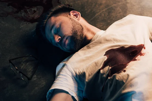 Homme mort avec du sang sur le t-shirt par terre sur la scène de crime — Photo de stock