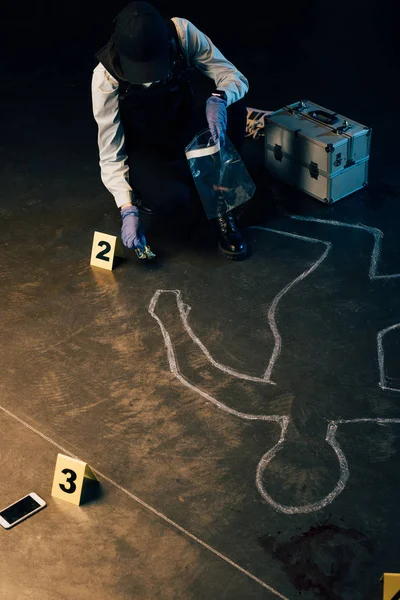 Следователь в форме собирает улики на месте преступления — стоковое фото