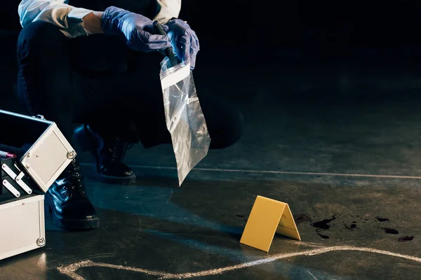 Visão recortada do investigador de uniforme com provas no local do crime — Fotografia de Stock