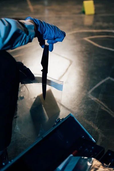 Partial view of investigator putting evidence in ziploc bag at crime scene — Stock Photo