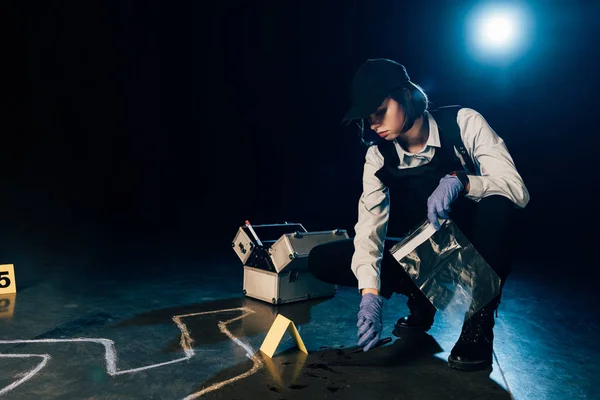 Investigator holding knife and ziploc bag at crime scene — Stock Photo