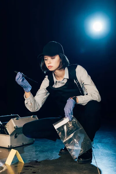 Investigador sosteniendo cuchillo y bolsa ziploc en la escena del crimen - foto de stock