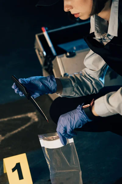 Ausgeschnittener Blick auf Ermittler mit Messer und Reißverschlusstasche am Tatort — Stockfoto