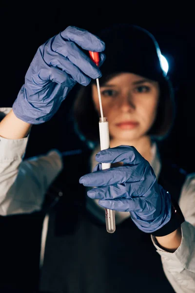 Selective focus of investigator in rubber gloves holding swab and test tube at crime scene — Stock Photo