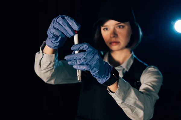 Selective focus of investigator in rubber gloves holding swab and test tube at crime scene — Stock Photo