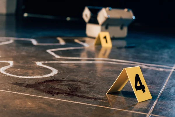 Chalk outline, blood stain, investigation kit and evidence markers at crime scene — Stock Photo