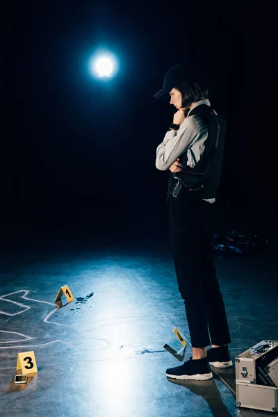 Full length view of investigator looking at evidences at crime scene — Stock Photo