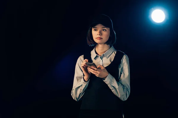 Nachdenklicher Ermittler in Uniform nutzt Smartphone und schaut weg — Stockfoto