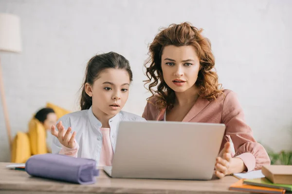 Découragé femme et fille geste tout en utilisant ordinateur portable ensemble — Photo de stock