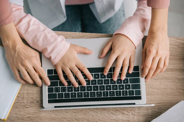 Visão parcial da mulher na criança usando laptop juntos ao fazer lição de casa — Fotografia de Stock