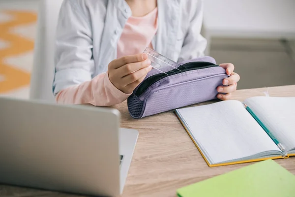 Vista recortada de niño conseguir regla fuera del estuche de lápiz mientras hace la tarea — Stock Photo