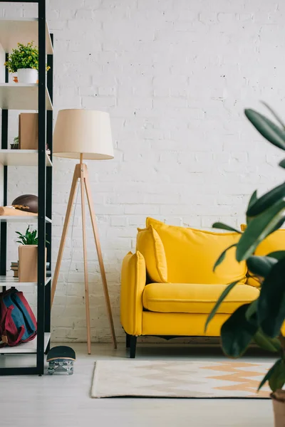 Helles Wohnzimmer mit gelbem Sofa, Ablage, Teppich am Boden und Stehlampe — Stockfoto