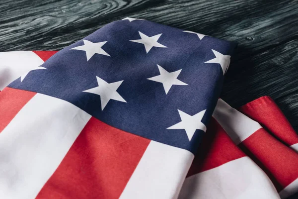 Folded united states national flag on grey wooden surface, memorial day concept — Stock Photo