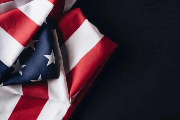 Piegato Stati Uniti d'America bandiera nazionale isolata sul nero, concetto giorno memoriale — Foto stock