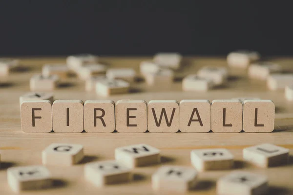 Selective focus of firewall inscription on cubes surrounded by blocks with letters on wooden surface isolated on black — Stock Photo