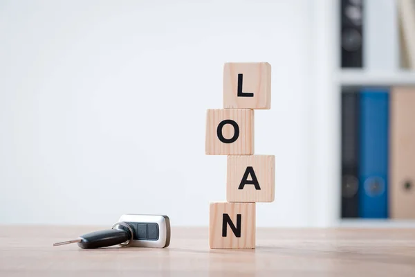 Car keys and wooden cubes with word loan on wooden tabletop surface in office — Stock Photo