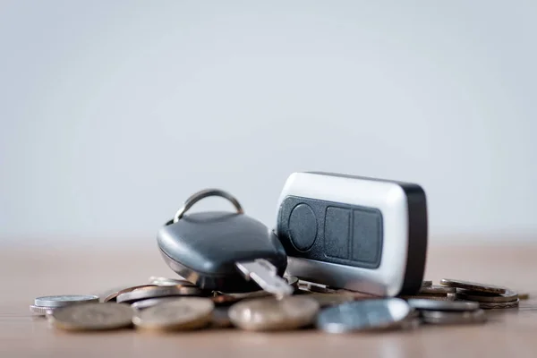 Car keys and metal coins on wooden surface isolated on grey — Stock Photo