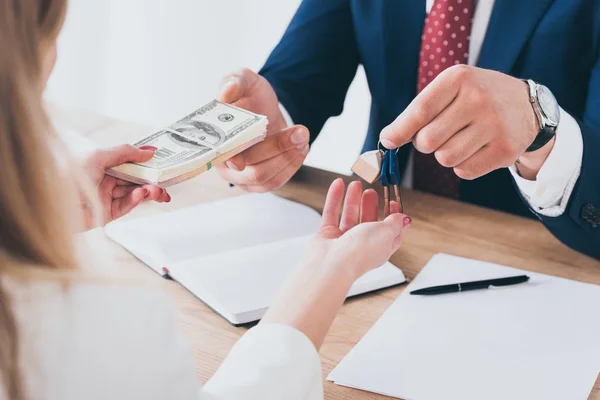 Plan recadré d'un homme d'affaires prenant des billets de banque en dollars de la femme et donnant des clés de voiture — Photo de stock