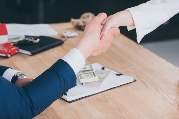 Vue partielle de l'homme d'affaires serrant la main avec le client au bureau — Photo de stock