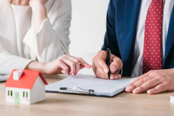 Vista parziale della donna d'affari che indica il luogo della firma nel contratto di prestito vicino alla penna di detenzione del cliente — Foto stock