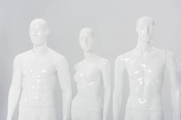 White plastic mannequin dolls isolated on grey — Stock Photo