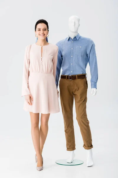 Beautiful smiling girl holding hands with mannequin on grey — Stock Photo